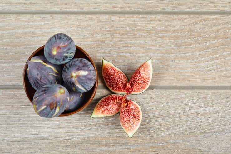 top-view-bowl-black-figs-slices-figs-wooden-table-high-quality-photo_114579-44261 (1)